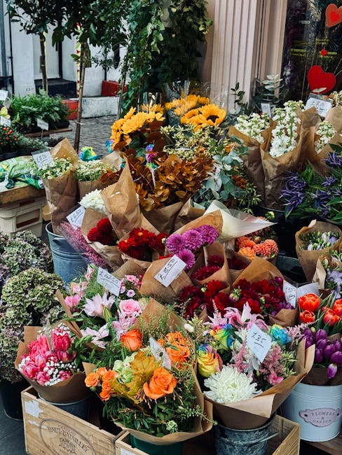 A vibrant display of freshly arranged flower bouquets at a flower shop, featuring a variety of colorful blooms including pink roses, orange marigolds, purple irises, white lilies, and red dahlias, eac